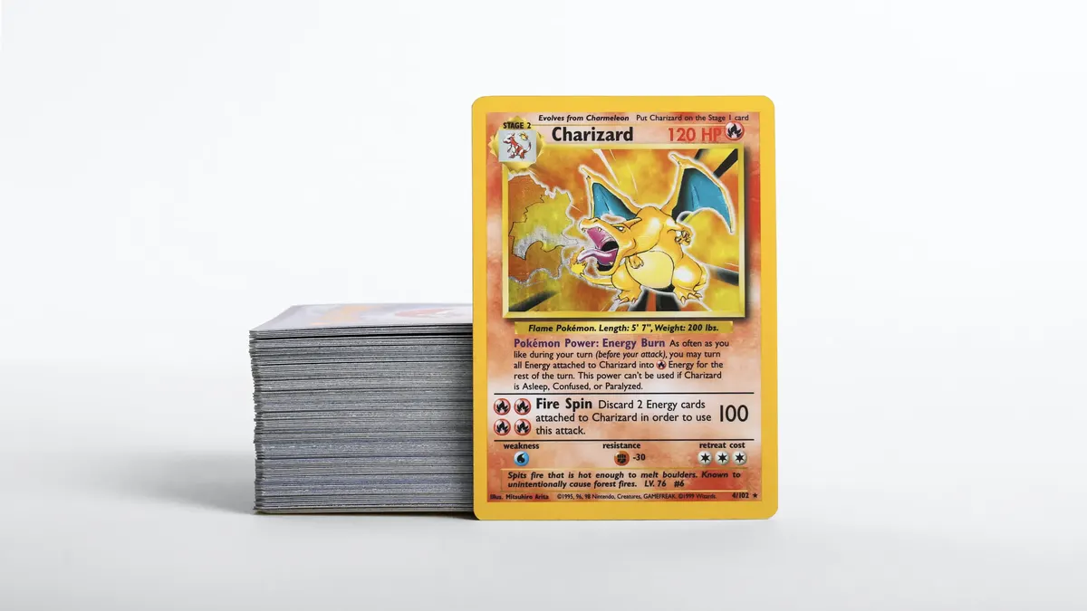 A stack of vintage Pokémon cards with a Base Set Charizard on top